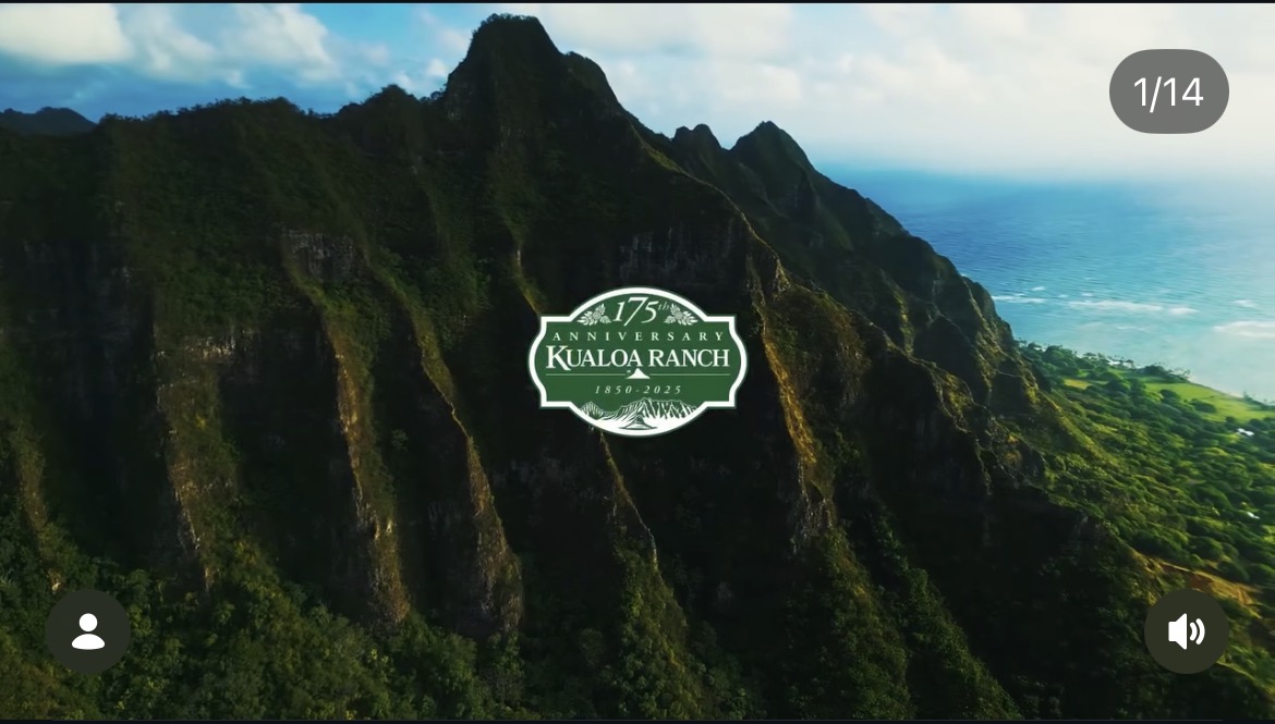 Green mountains and ocean at Kualoa Ranch, with its anniversary emblem